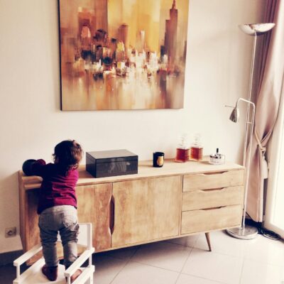 Toddler Standing on White Chair Beside Sideboard